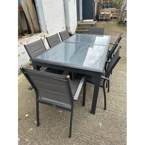 355 - A contemporary grey metal garden table with two piece glass top and eight garden chairs by Alice’s G... 