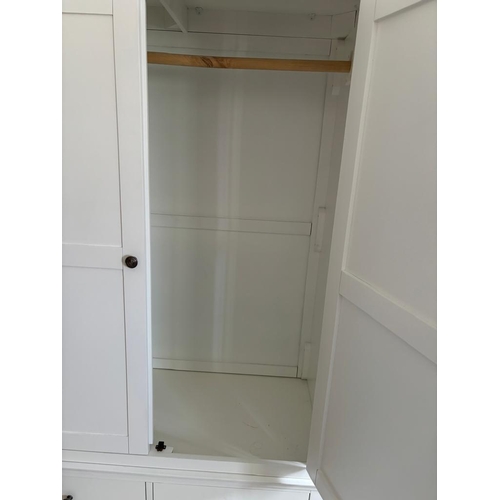 36 - A white two door wardrobe with four drawers below and hanging space above (H200cm W114cm D55cm)