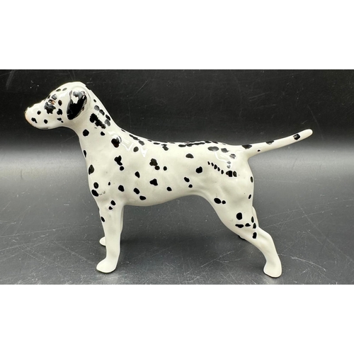 385 - A Beswick figure of a Dalmation dog (8.5cm High) along with a Royal Copenhagen porcelain puppy.