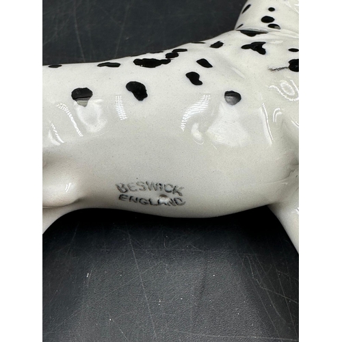 385 - A Beswick figure of a Dalmation dog (8.5cm High) along with a Royal Copenhagen porcelain puppy.