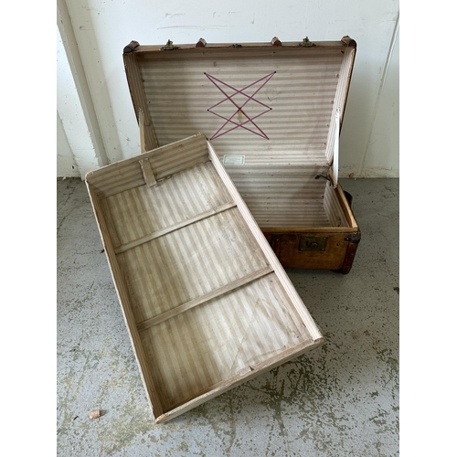 40 - A vintage wooden banded steamer trunk with brass fittings, opening to single shelf with stripped cot... 