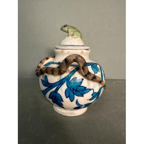 404 - A small Chinese style teapot with a blue leaf design, snake handle and a decorative frog finial to l... 