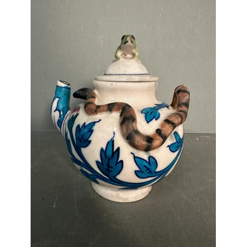 404 - A small Chinese style teapot with a blue leaf design, snake handle and a decorative frog finial to l... 