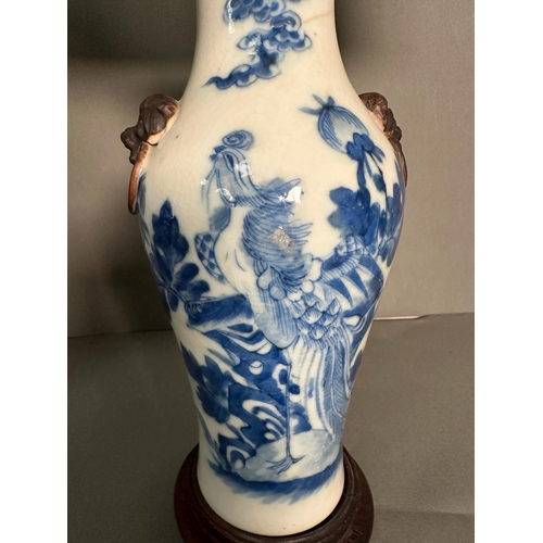 427 - A pair of Chinese blue and white table lamps in a floral bird pattern with foo dogs to side