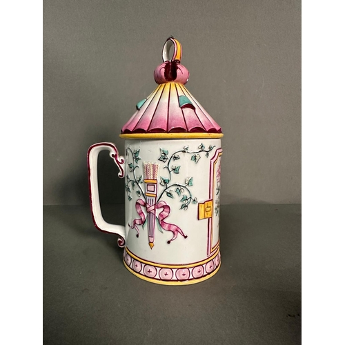 437 - A French lidded mug decorated in pinks and yellows with floral central shield