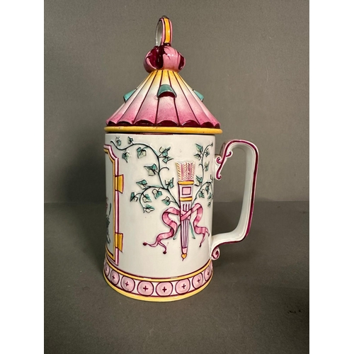 437 - A French lidded mug decorated in pinks and yellows with floral central shield