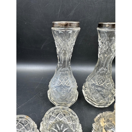 508 - A selection of cut glass cruets with silver tops, hallmarked for Chester and two silver topped vases... 