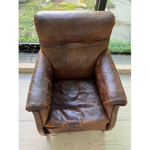 54 - An antique leather club chair in distressed manner with scrolling arms (H95cm W71cm D31cm SH43cm)Cro... 