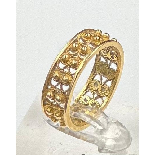 557 - An Arabian gold band ring with filigree decoration, approximate total weight 4g. Size P