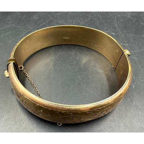 599 - A 1/5 9ct rolled gold bangle engraved on a scrolling pattern