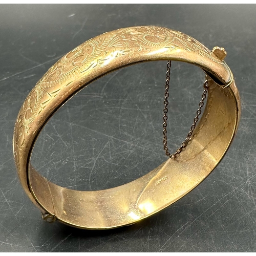 599 - A 1/5 9ct rolled gold bangle engraved on a scrolling pattern