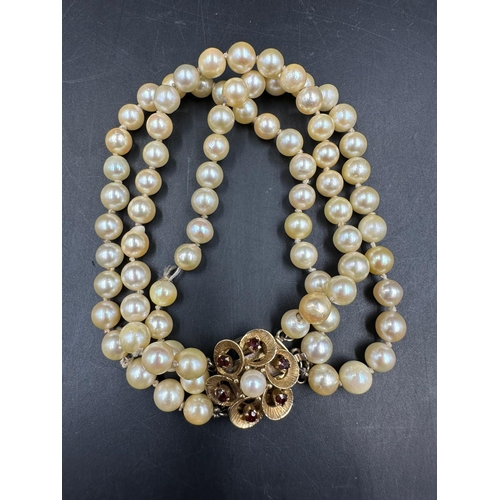 619 - A three strand pearl necklace and three strand pearl bracelet on floral designed 9ct gold fastener w... 