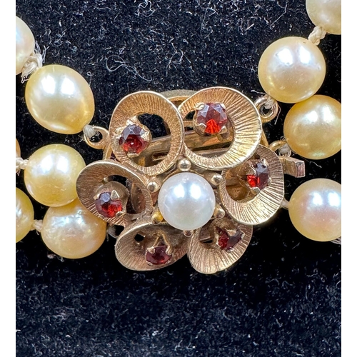 619 - A three strand pearl necklace and three strand pearl bracelet on floral designed 9ct gold fastener w... 