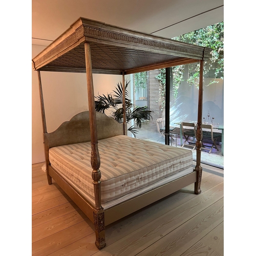 65 - A four poster bed with carved posts and scrolling finals, the shaped bed head and canopy above carve... 