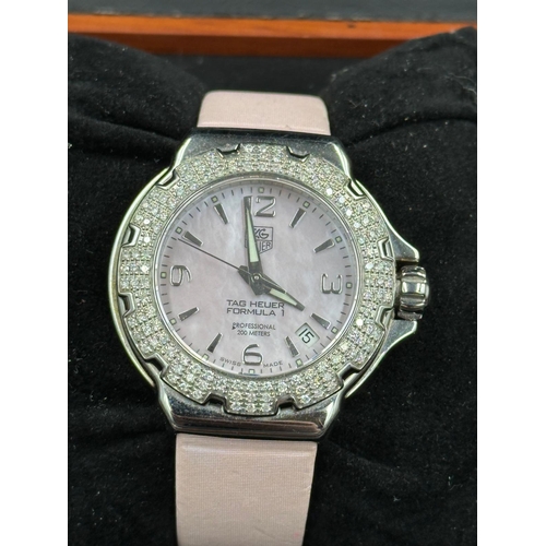 704 - A Ladies Tag Heuer Formula 1 watch with diamond bezel, box and papers on pink leather strap with pin... 