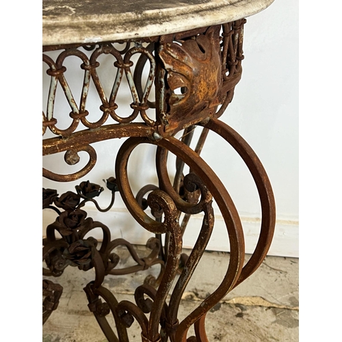 78 - A French marble topped circular table with scrolling iron twin legs (H78cm Dia66cm)