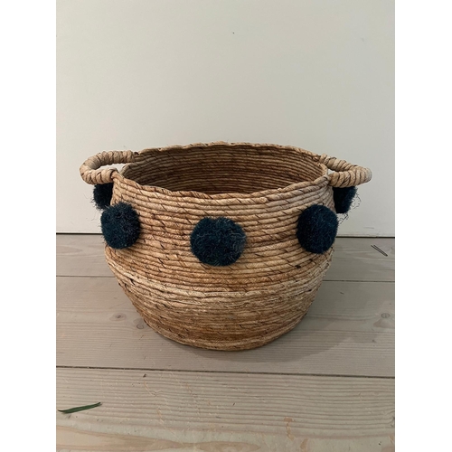 790 - A wove rush basket with pom poms (H32cm W59cm)