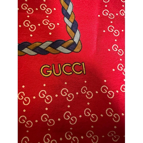 809 - A Vintage Gucci 100% silk scarf on red with logo.