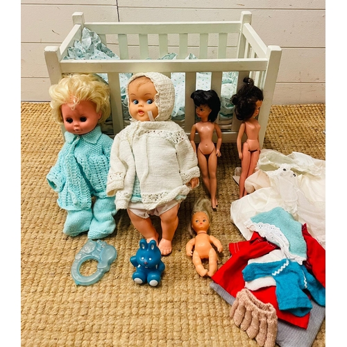 832 - A vintage white wooden children's toy doll cot with dolls, bedding and toys