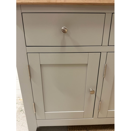 93 - A grey painted three drawer and three cupboard sideboard (H83cm W139cm D42cm)