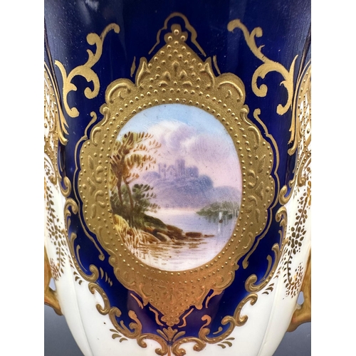 434A - An early 20th Century Coalport, three handled goblet with blue grounds under a acid etch gilt boarde... 