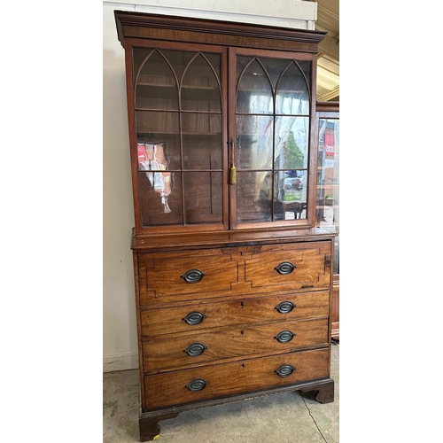 63 - A Georgian mahogany secretaire bookcase, glazed doors opening to shelves, the base fitted with strun... 