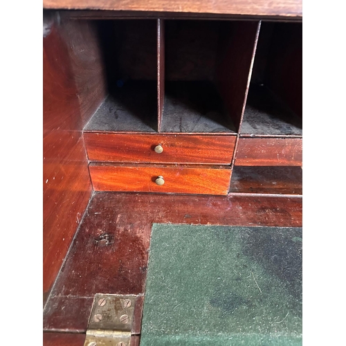 63 - A Georgian mahogany secretaire bookcase, glazed doors opening to shelves, the base fitted with strun... 