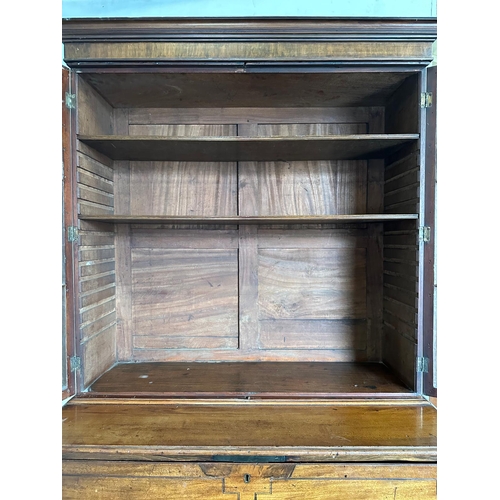 63 - A Georgian mahogany secretaire bookcase, glazed doors opening to shelves, the base fitted with strun... 