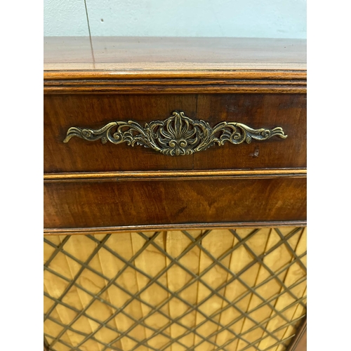 135 - A Regency style side cabinet silk lined, brass lattice doors opening to shelves (H90cm W120cm D29cm)