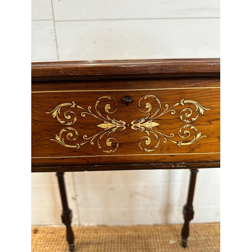 17 - A Victorian bijouterie table with string and scrolling floral inlay on turned legs and casters with ... 