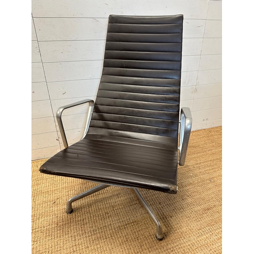 21 - A brown leather and aluminum lounge armchair by Charles Eames for Vitra