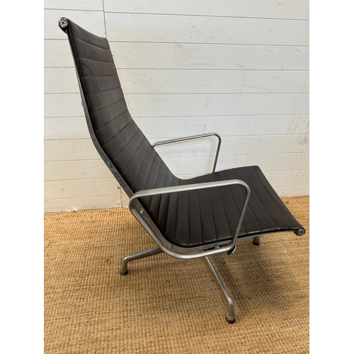 21 - A brown leather and aluminum lounge armchair by Charles Eames for Vitra