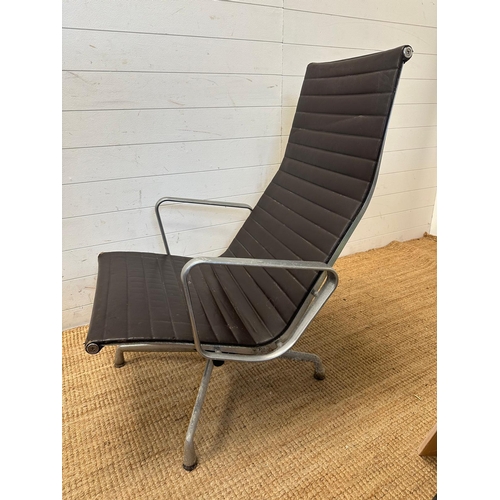 22 - A brown leather and aluminum lounge armchair by Charles Eames for Vitra