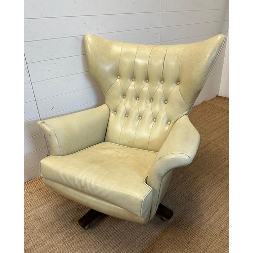 23 - A G-Plan wing backed white leather arm chair on a swivel base