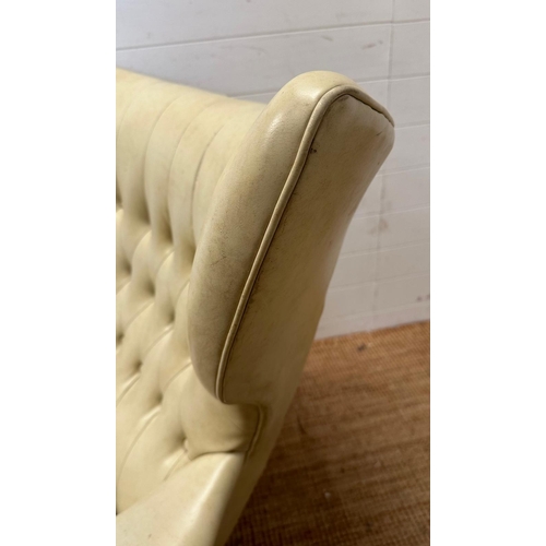 23 - A G-Plan wing backed white leather arm chair on a swivel base