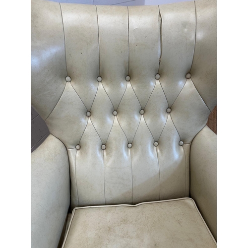 23 - A G-Plan wing backed white leather arm chair on a swivel base