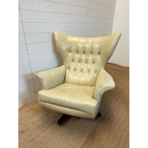 23 - A G-Plan wing backed white leather arm chair on a swivel base