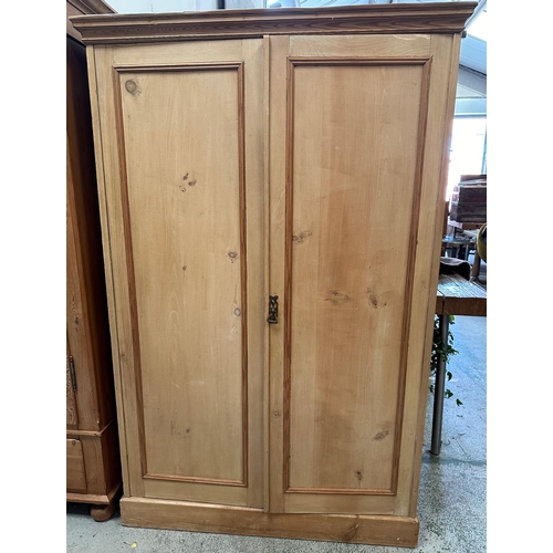 36 - A distressed pine two door cupboard opening to four shelves (H168cm W109cm D46cm)