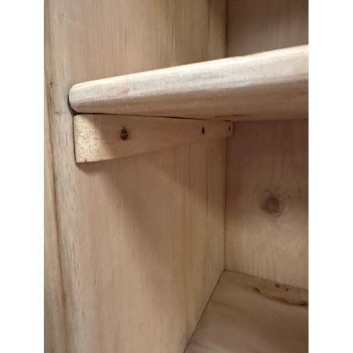 36 - A distressed pine two door cupboard opening to four shelves (H168cm W109cm D46cm)