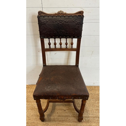 49 - A French oak and embossed leather hall chair, turned front legs and ornate floral pattern to seat ba... 