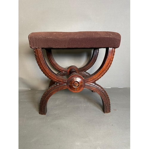 5 - A Victorian mahogany x frame footstool finished in floral upholstery.