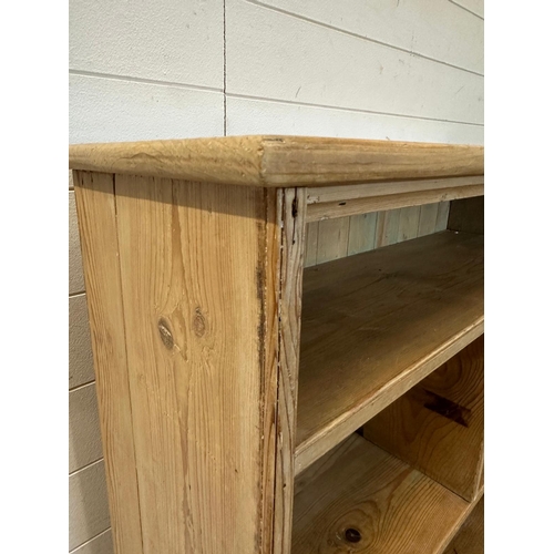 58 - A pine three shelf bookcase, the middle shelf separated into two compartments (H102cm W96cm D31cm)