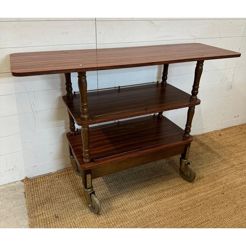 62 - A Mid Century three tier trolly with veneered tops, turned support and on industrial style castors (... 