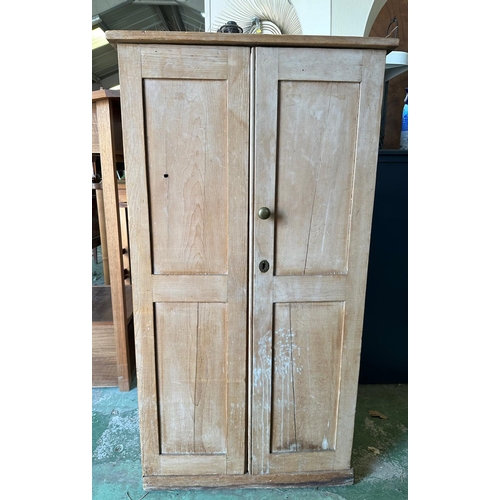 63 - A vintage weathered pine two door cupboard opening to eleven shelved compartments (H125cm W66cm D49c... 