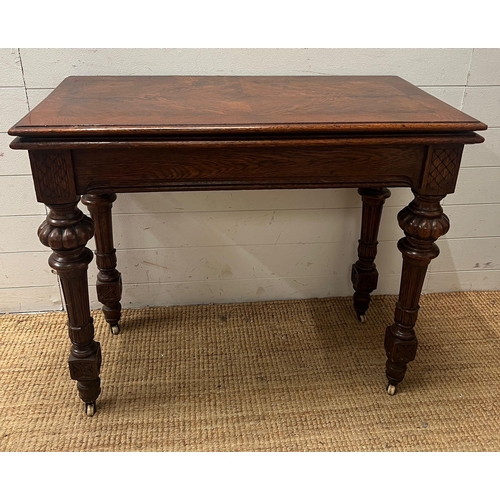 77 - A Victorian card table, fold over top opening to reveal green baize interior on reeded legs and cast... 