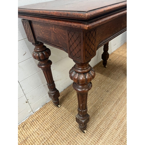 77 - A Victorian card table, fold over top opening to reveal green baize interior on reeded legs and cast... 