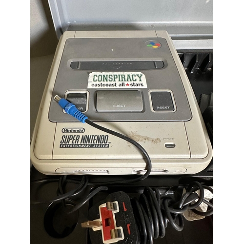 787 - A Super Nintendo games console with a collection of game cartridge to include Super Mario Kart and M... 