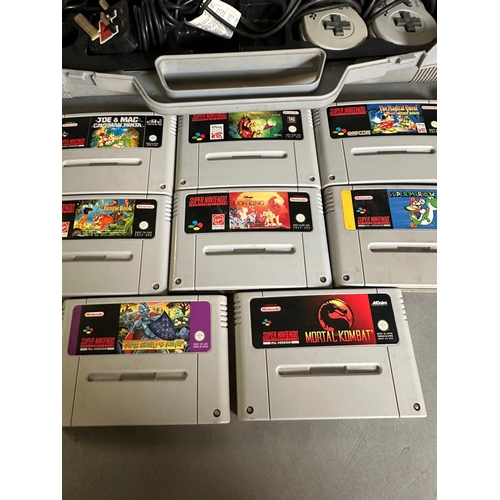 787 - A Super Nintendo games console with a collection of game cartridge to include Super Mario Kart and M... 