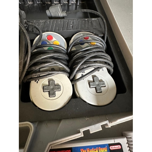 787 - A Super Nintendo games console with a collection of game cartridge to include Super Mario Kart and M... 