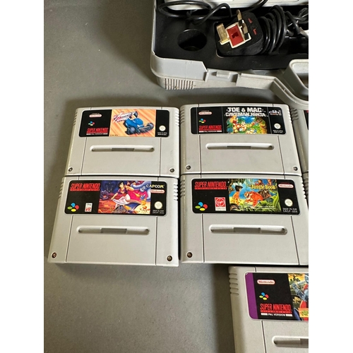 787 - A Super Nintendo games console with a collection of game cartridge to include Super Mario Kart and M... 